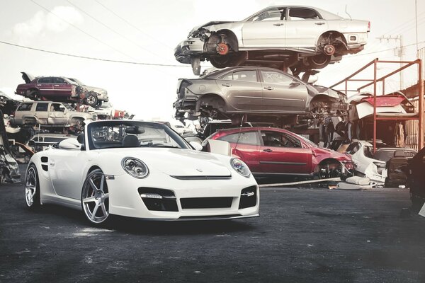 Super Porsche car on the background of a pile of metal