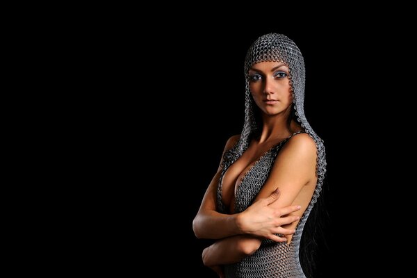 A girl with makeup and in chain mail on a black background