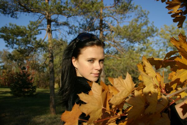 Chica en el fondo de un paisaje de otoño con árboles