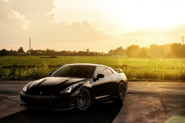 Nissan sombre sur le terrain sous le soleil