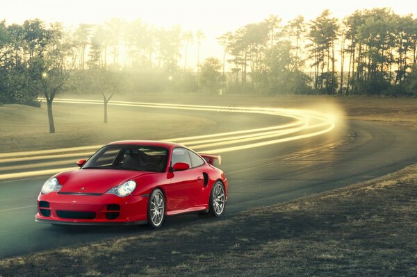 Red Porsche on the road against the background of nature