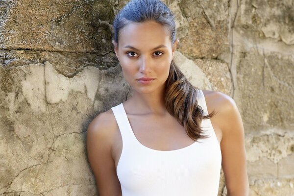 Photo of a girl in a T-shirt on the background of rocks