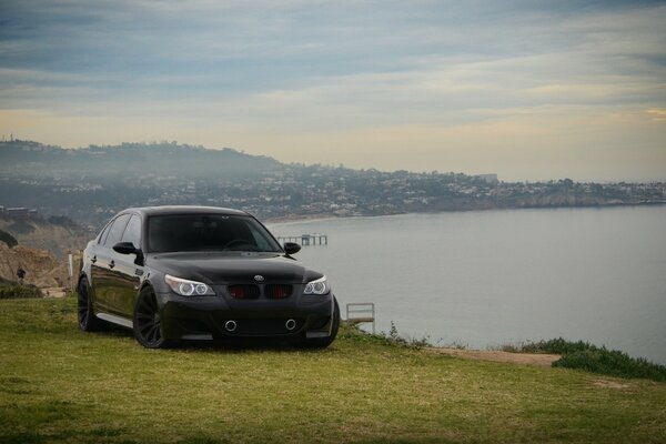 Negro BMW Sedan en la orilla del lago