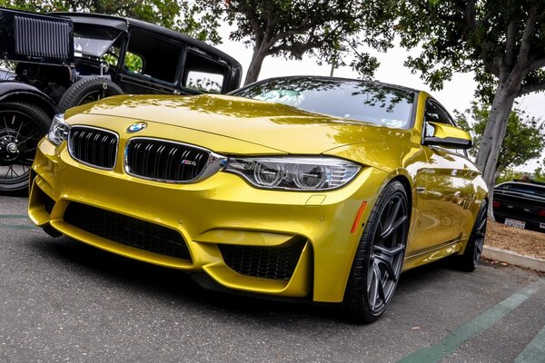 Une BMW dorée se dresse sur le parking