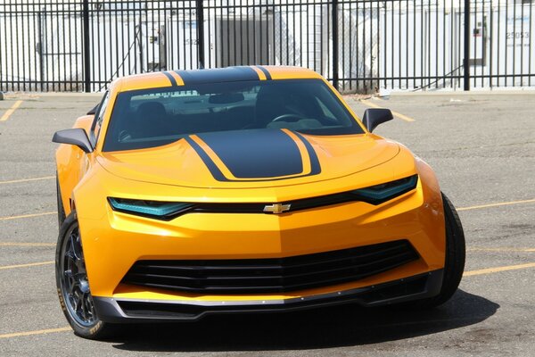 Heißer süßer Chevrolet Camaro auf einer sonnigen Straße vor dem Hintergrund eines Zauns