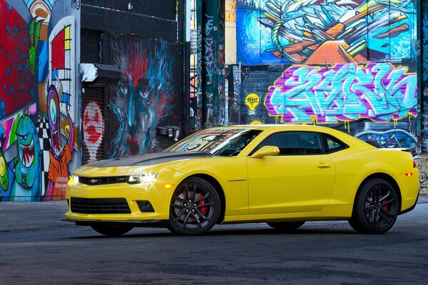 Car corvette camaro yellow against the wall with graffiti