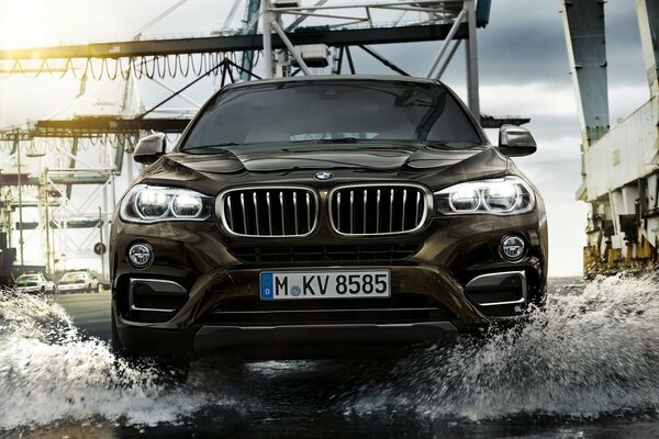 Un crossover BMW noir se précipite dans une flaque d eau