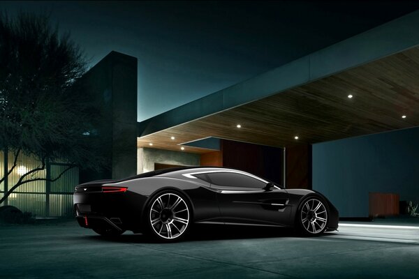 Czarny samochód na tle luksusowego domu w nocy