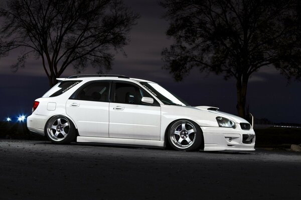 Blanc Subaru promenades dans la ville de nuit