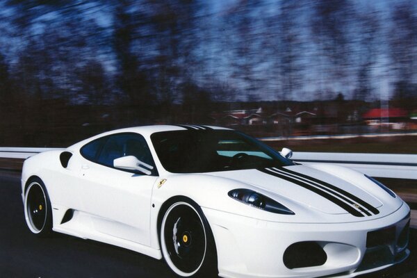 A white Ferrari is racing on the highway