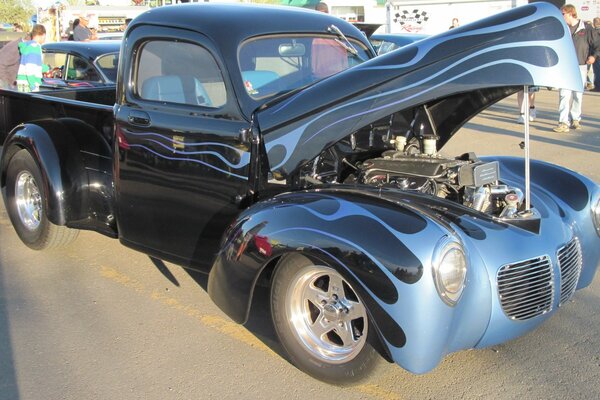 Blue and black pickup truck with open hood