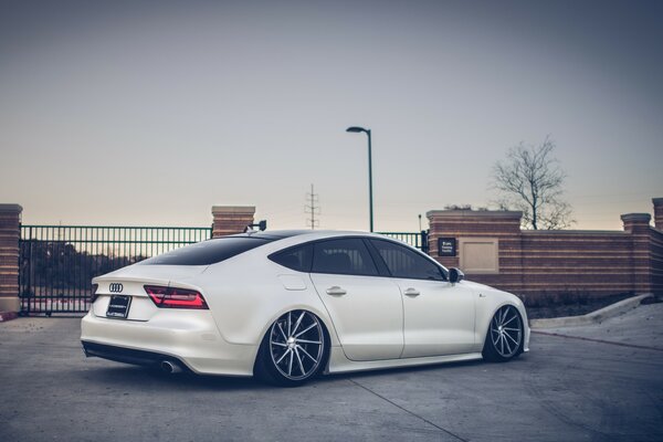 A white Audi stands on concrete