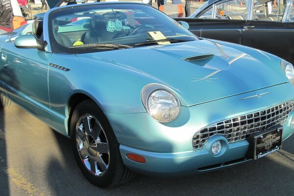 Blue Ford convertible with round headlights