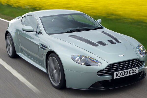 Samochód Aston jedzie szybko po drodze ekspresowej