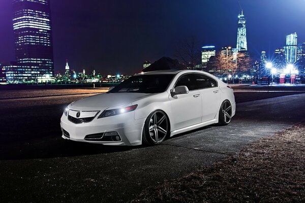 Honda Acura blanc avec roues tuning sur fond de ville