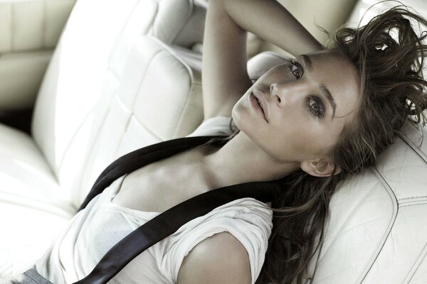 A girl poses in the back seat of a car