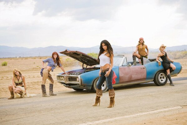 Cinco chicas en el desierto cerca de un coche