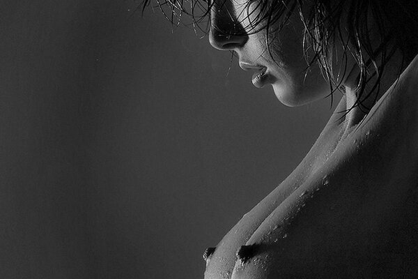Black and white photo of a girl with bare breasts