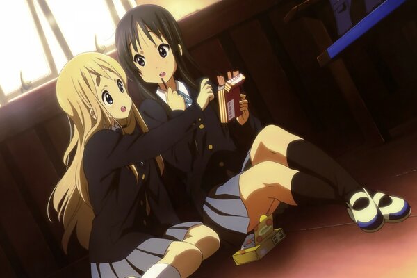 Anime. Two schoolgirls are sitting on the floor