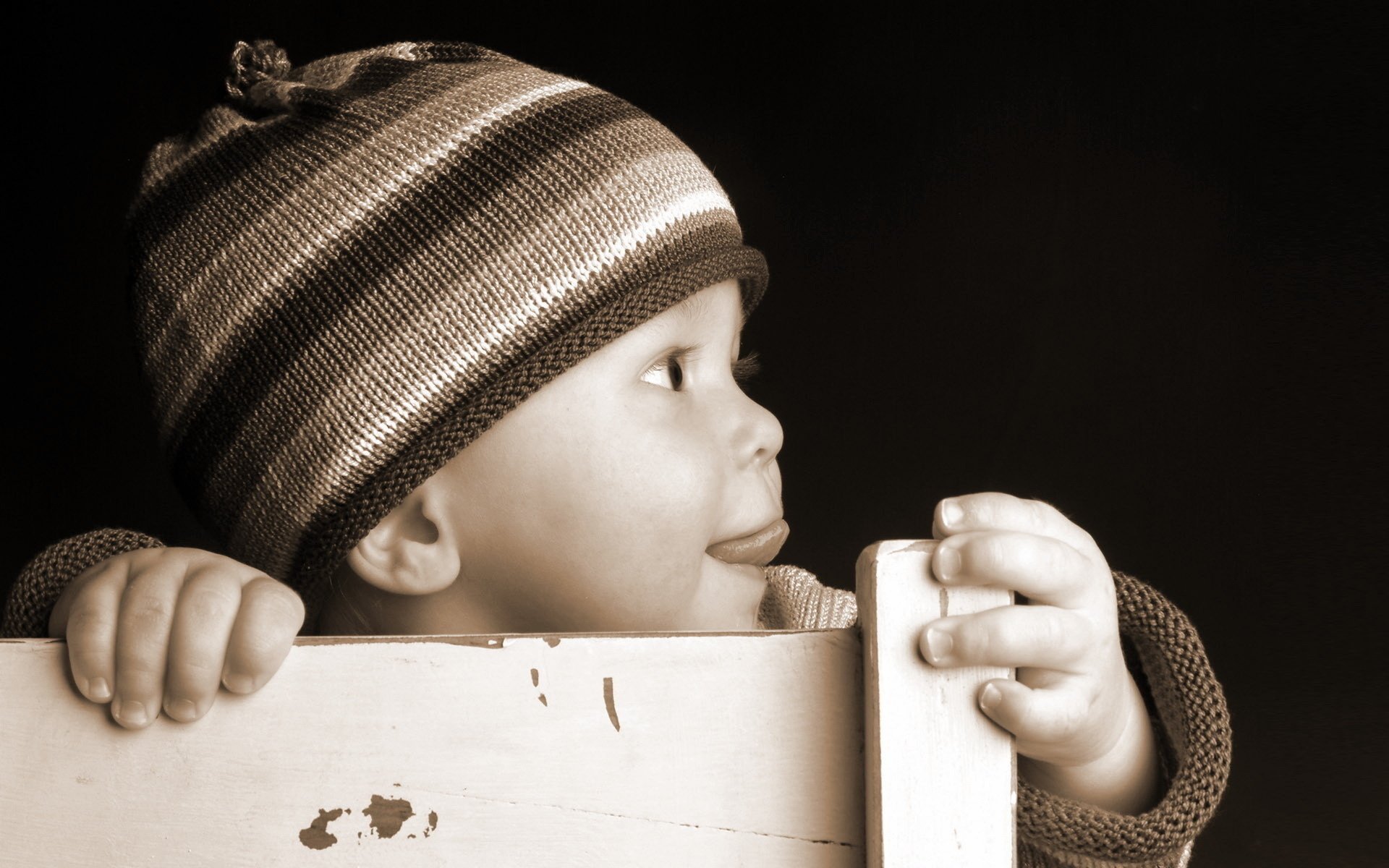 triped hat baby high chair portrait look face profile baby child headdress black background chair