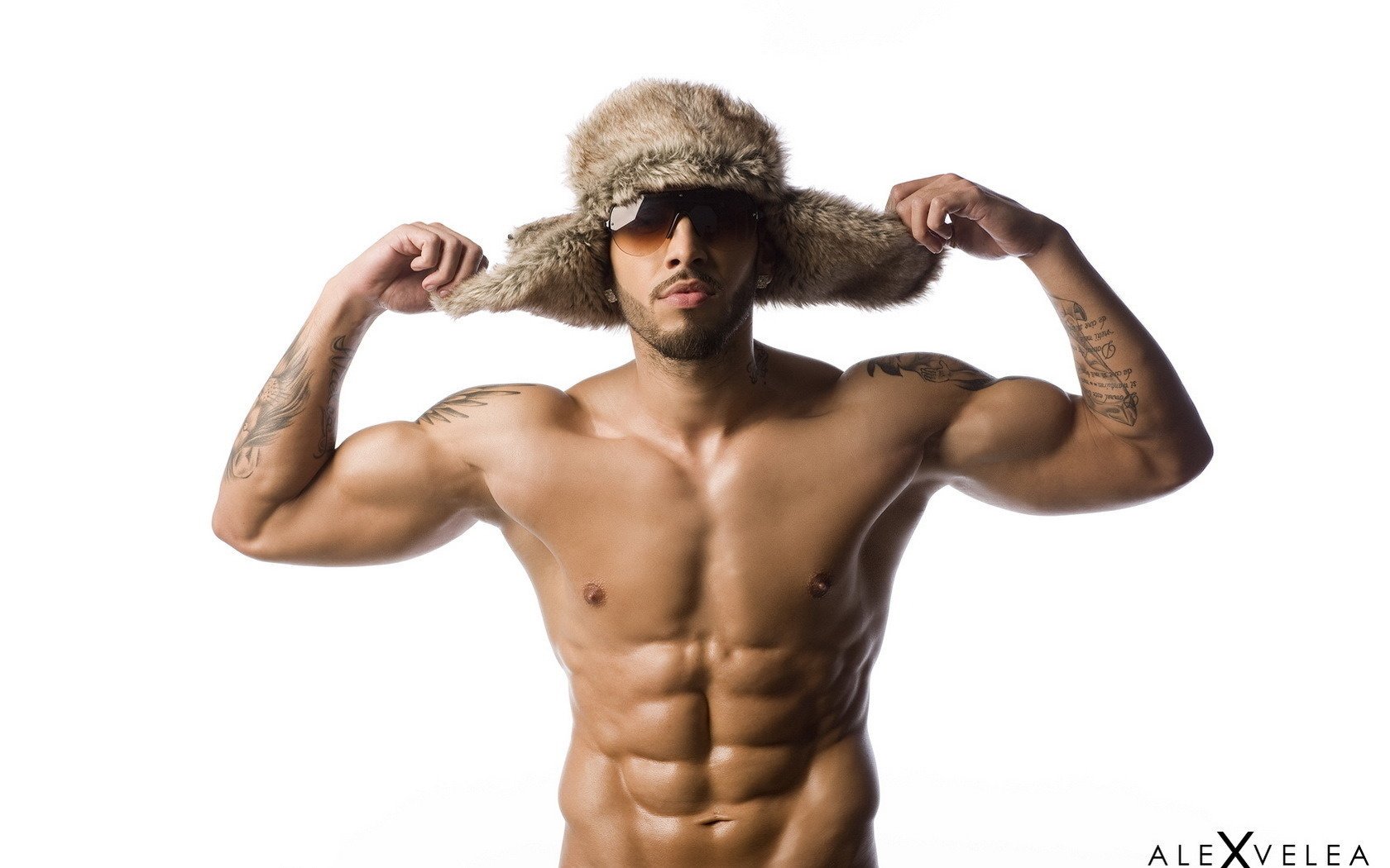 hombre inflado sombrero de piel sombrero de ushanka cerdas jock tatuaje músculos torso gafas sin afeitar fondo fondo blanco cara