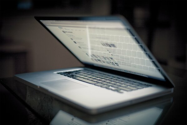 Macbook pro это ноутбук с яблоком и клавиатурой отличен на столе