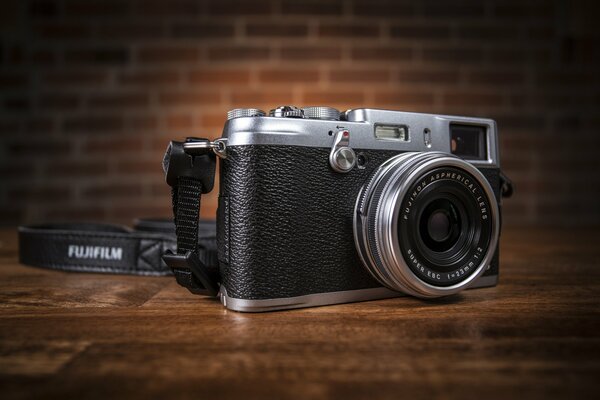 Fuji x100 s on a table on a wall background