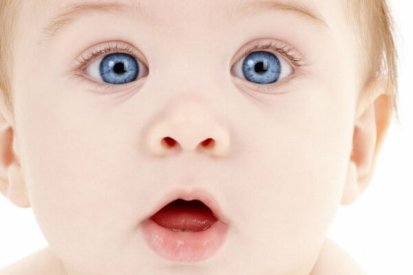 Bébé aux yeux bleus avec la bouche ouverte