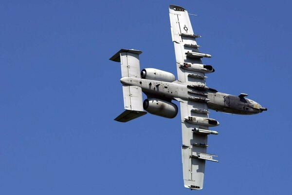 The plane is flying through a clear blue sky