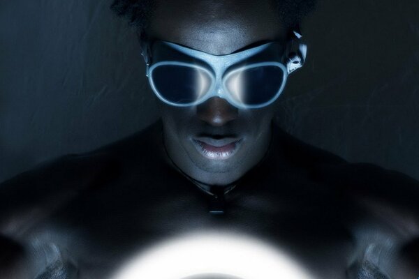 Ein dunkel gekleideter Mann mit Schutzbrille schaut auf das Licht