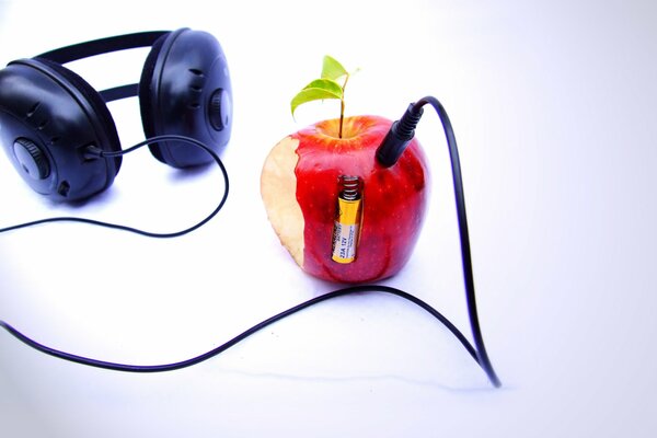 Roter Apfel im Kopfhörer mit Batterie