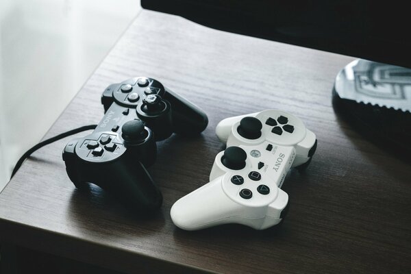 Two gamepads black and white on the table