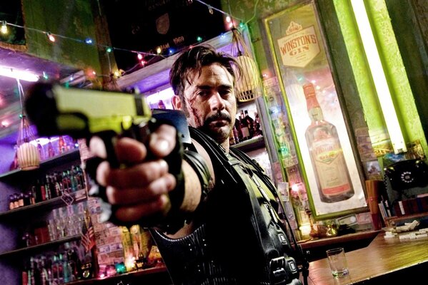 Homme avec des armes dans le bar, près du comptoir de bar