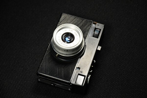 Ретро фотоаппарат серебристый на черном фоне