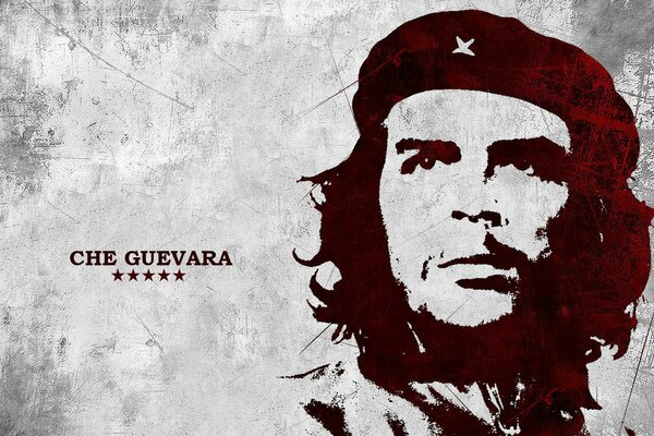 Che Guevara s piercing gaze from the portrait on the gray wall