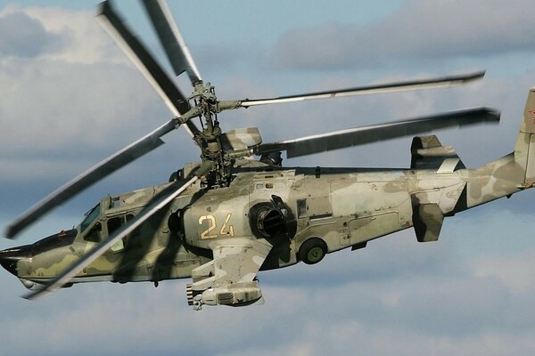 A combat military helicopter flies across any sky