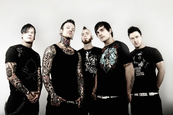 A musical group of four men with tattoos on their arms