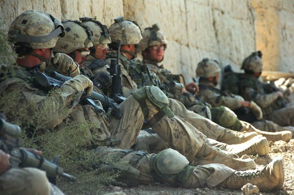 Camper, die Soldaten in Uniform an der Wand sitzen