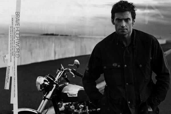 Hugh Jackman poses by a motorcycle