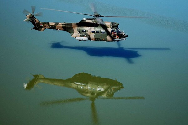 Elicottero militare sospeso sopra la superficie dell acqua