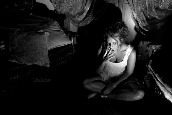 A girl in black and white near the bed