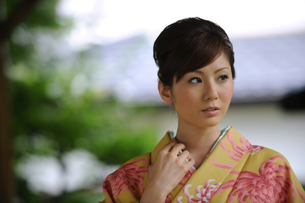 Portrait of a Japanese woman in a kimono against the background of nature