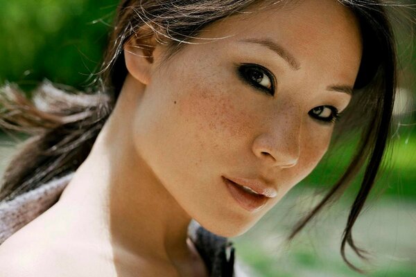 Lucy Liu s face with black painted eyes