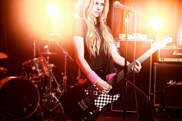 Blonde Avril Lavigne im Club mit Gitarre