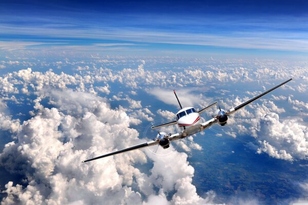 Flugzeug hoch in den Wolken unter blauem Himmel