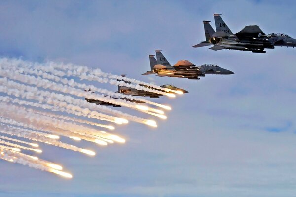 A flight of fighter planes that produce light bombs