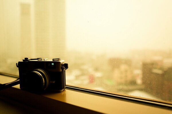 A camera standing on a narrow windowsill