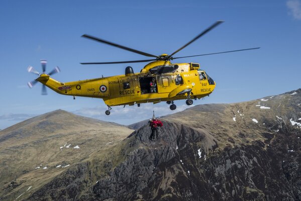 Helicóptero de rescate amarillo sobre las montañas