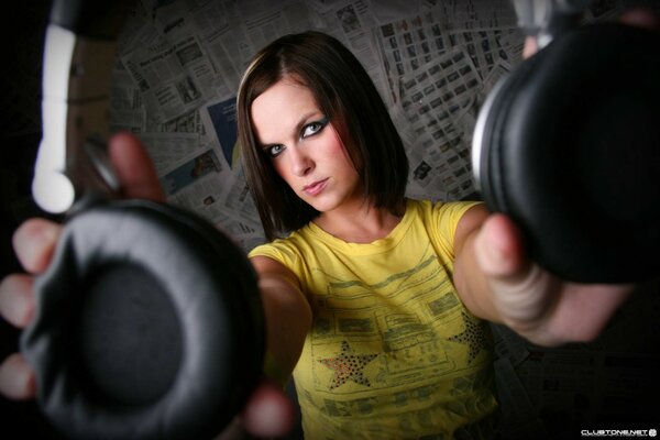 A girl with headphones in a yellow T-shirt