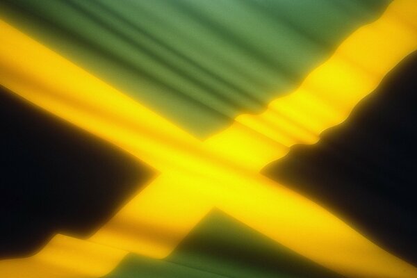 Image of the yellow-green flag of Jamaica, fluttering in the wind